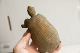 Angled view of the hand-carved geometric patterns on the tortoise sculpture's shell.