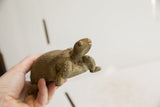 Side profile of the small African tortoise sculpture showing its aged texture.