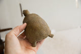 Earthy texture and carved geometric squares on the African tortoise sculpture's shell.