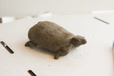 Side profile of the vintage tortoise showing its carved geometric shell pattern.