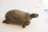 Side profile of the vintage tortoise sculpture, showing its aged patina and carved form.