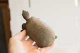Angled view of the vintage tortoise sculpture held in hand, showing its profile and carved shell.