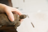 Vintage tortoise sculpture held in hand, highlighting its aged, textured surface.