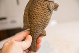Collectible African fish sculpture held to show its rustic handmade texture.