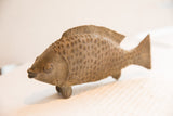 Vintage African fish sculpture in profile, highlighting its carved scales and rustic finish.
