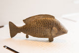 Detailed side view of a vintage fish sculpture showing its rustic, hand-carved texture.