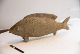Hand-carved vintage African fish sculpture showing its textured scales from the side.