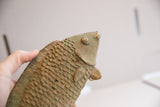 View looking up at the vintage fish sculpture, highlighting its detailed scales and aged patina.