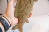 The vintage African fish sculpture's earthy finish and textured, carved scales.