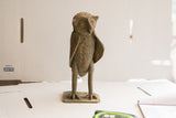 Three-quarter profile view of the handmade African owl sculpture with textured details.
