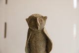 Face of the vintage African owl sculpture showing its carved eyes and weathered patina.