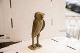 Detail of the vintage African owl's textured face and aged green-brown finish.