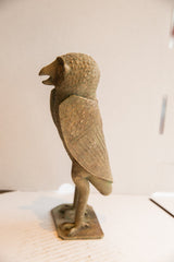 Vintage African owl sculpture, side view, with textured patina and patterned wings.