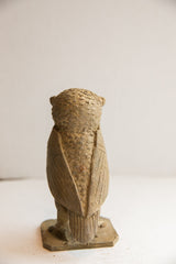 Rear view of a vintage African owl sculpture showing its carved wings and textured head.