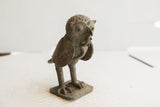 Vintage African owl sculpture in profile, showing its large eyes and textured handmade surface.