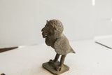 Three-quarter profile of the vintage owl sculpture showing its handmade texture and aged patina.