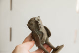 Side profile of a vintage African owl sculpture showing its aged, handmade texture.
