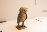 Angled view of the vintage owl sculpture highlighting its handmade texture and aged patina.