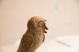 Vintage African owl sculpture with a rough, earthy texture, shown in profile view.