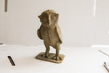 Vintage African owl sculpture's rough textured legs and base, in earthy tones.