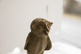 Textured close-up of the vintage African owl sculpture's head and handmade surface.
