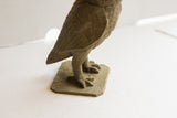 Vintage African owl sculpture's textured legs and clawed feet on its base.