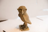 Detailed view of the vintage owl sculpture's face, showing its rustic, earthy texture.