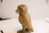 Side profile of the vintage African owl sculpture showing its textured body and open beak.