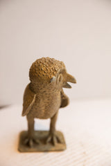 Angled view of the vintage African owl sculpture highlighting its pebbled, rustic surface.