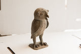 Profile of the vintage African owl sculpture showing its rough, handmade texture.