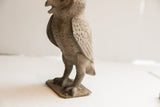 Side profile of the vintage owl sculpture highlighting its rustic texture and carved wings.