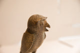 Profile view of the handmade African owl sculpture detailing its rustic, aged texture.