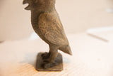 The hand-carved texture of the vintage African owl sculpture's wing and body.