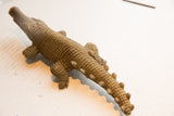 High-angle view of the vintage crocodile sculpture, showing its textured body and bumpy tail.