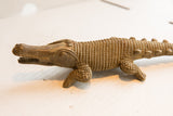 Handmade character and carved details on the face of a vintage crocodile sculpture.