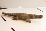 Side profile of the vintage handmade crocodile sculpture showing detailed carved texture.