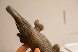 Close-up view showing the hand-carved eye and textured scales of the crocodile sculpture.