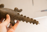 Side view showing the crocodile sculpture's hand-carved scales and textured tail.