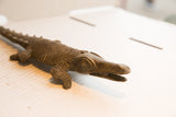 The hand-carved head and textured snout of a vintage African crocodile sculpture.