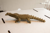 Side profile of the vintage African crocodile sculpture showing its detailed, textured body.