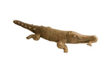Vintage African crocodile sculpture holding a fish, featuring a detailed, etched body texture.