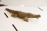 Three-quarters view of the vintage African crocodile sculpture showing its hand-etched scales.