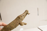 Profile view of the vintage crocodile sculpture's head with fish in its mouth, showing aged metal patina.