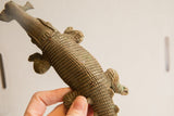 Detail view of the vintage crocodile sculpture's handmade, incised body texture.