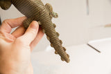 Vintage crocodile sculpture held in hand to show its ridged, textured tail.