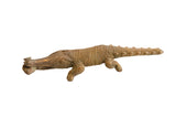Vintage African crocodile sculpture holding a fish, with a ribbed body and aged brass patina.