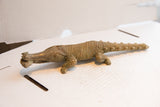 Side view of the vintage African crocodile sculpture, detailing its ribbed texture.