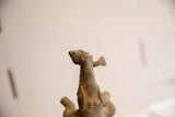 Detailed view of the fish held in the mouth of the crocodile sculpture.