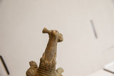 Upward view of the vintage crocodile sculpture's head and the fish in its mouth.