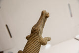 Low-angle view of the vintage African crocodile sculpture highlighting its carved texture.